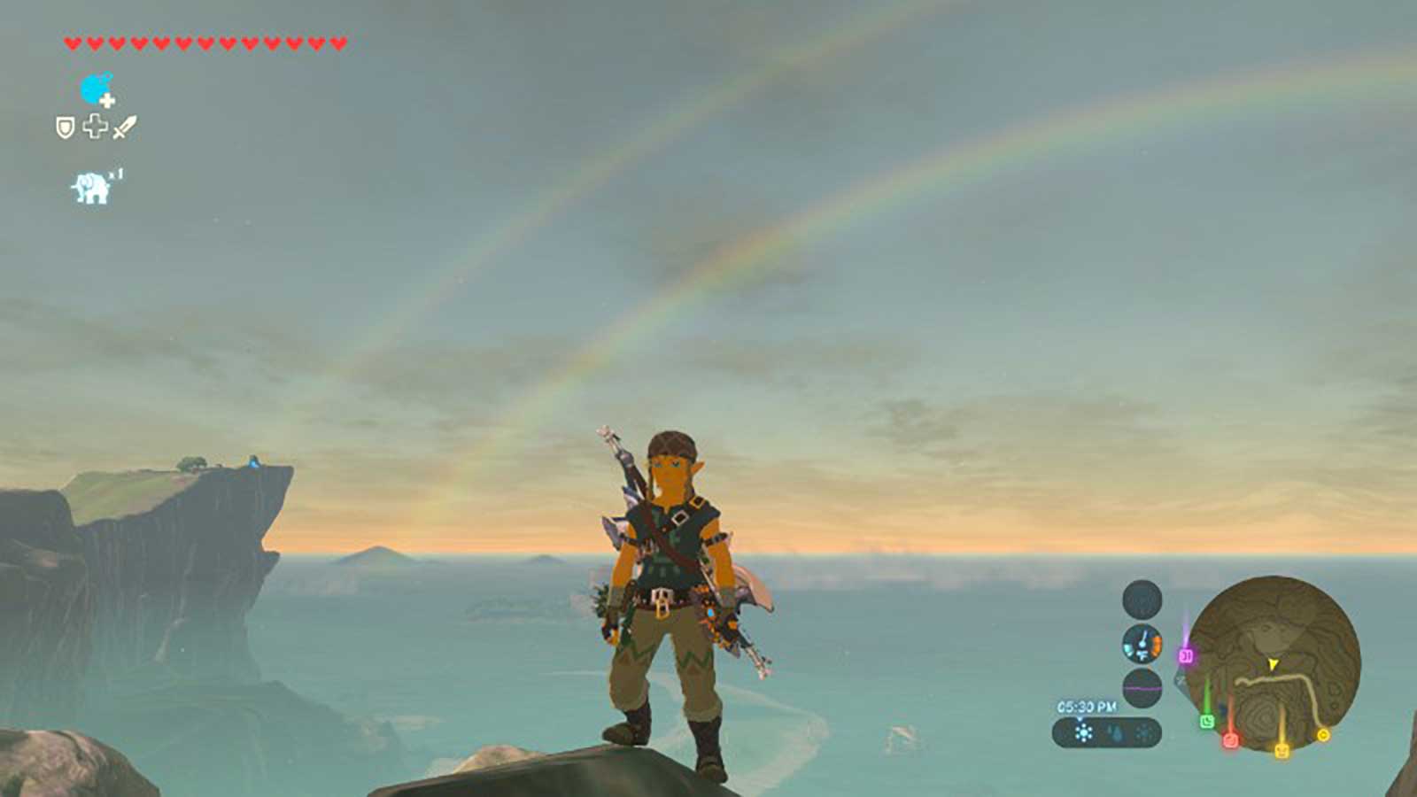 Link on the mountainside with a double rainbow apparent in the background